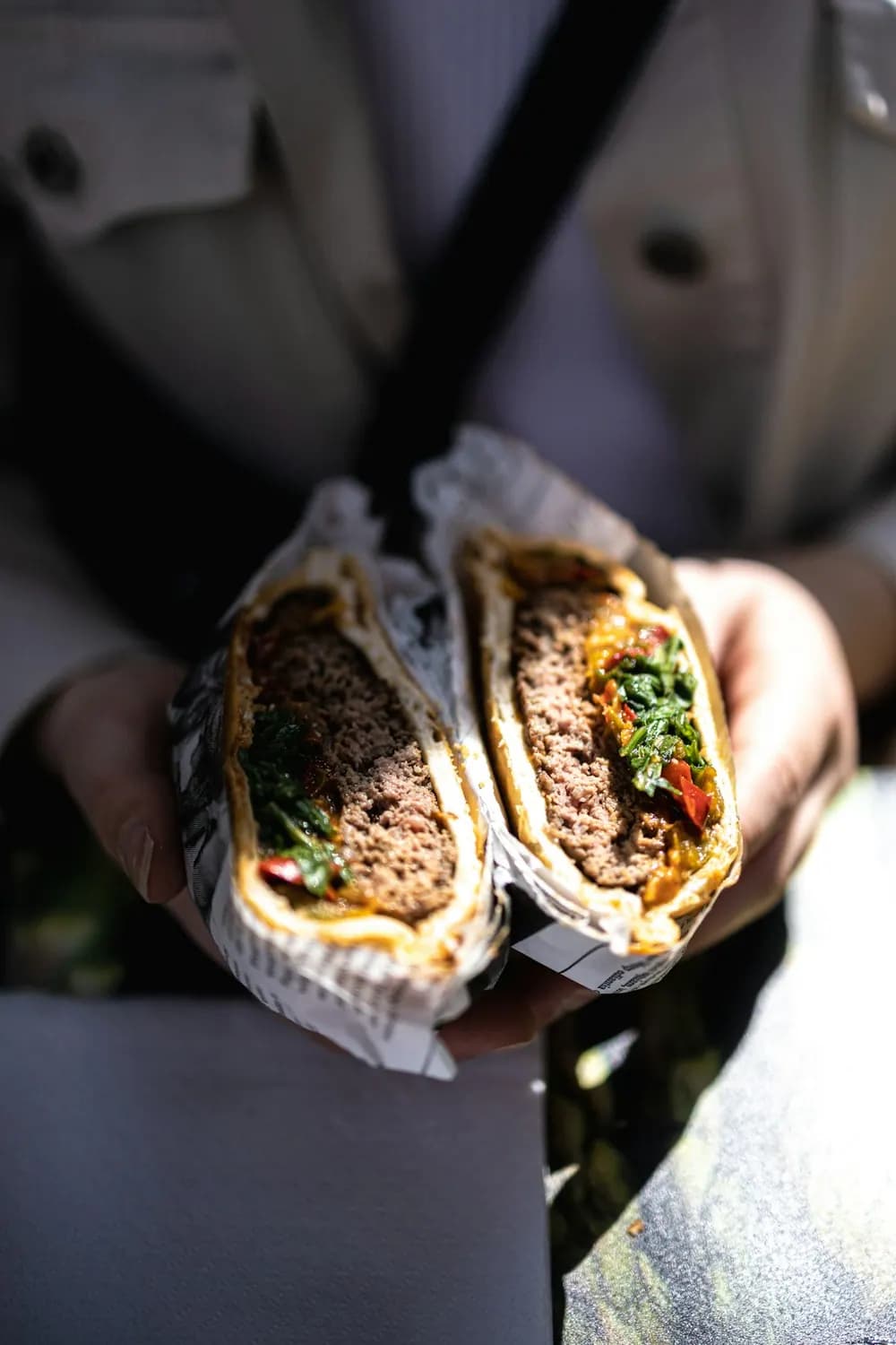 Menu kebab — kebab coupé en deux dans son papier, tenu en main